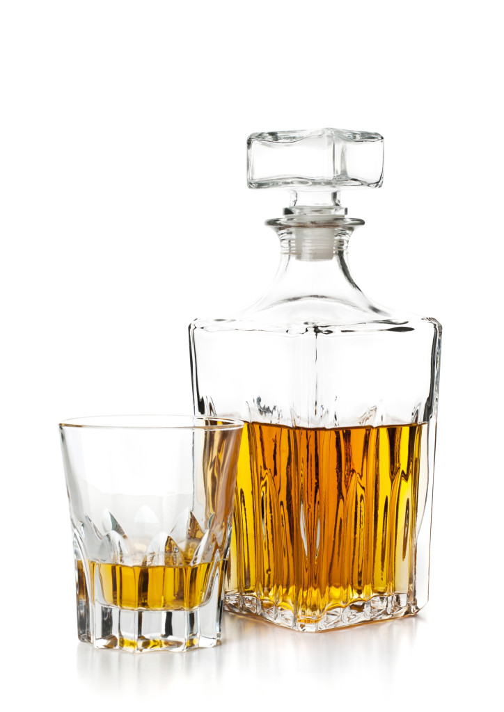 bottle and glass of whiskey on white background