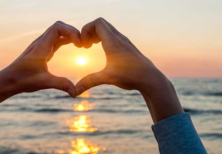 corazon de manos en playa